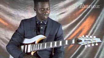 Guitarrista Tosin Abasi con la guitarra ibanez que lleva su nombre